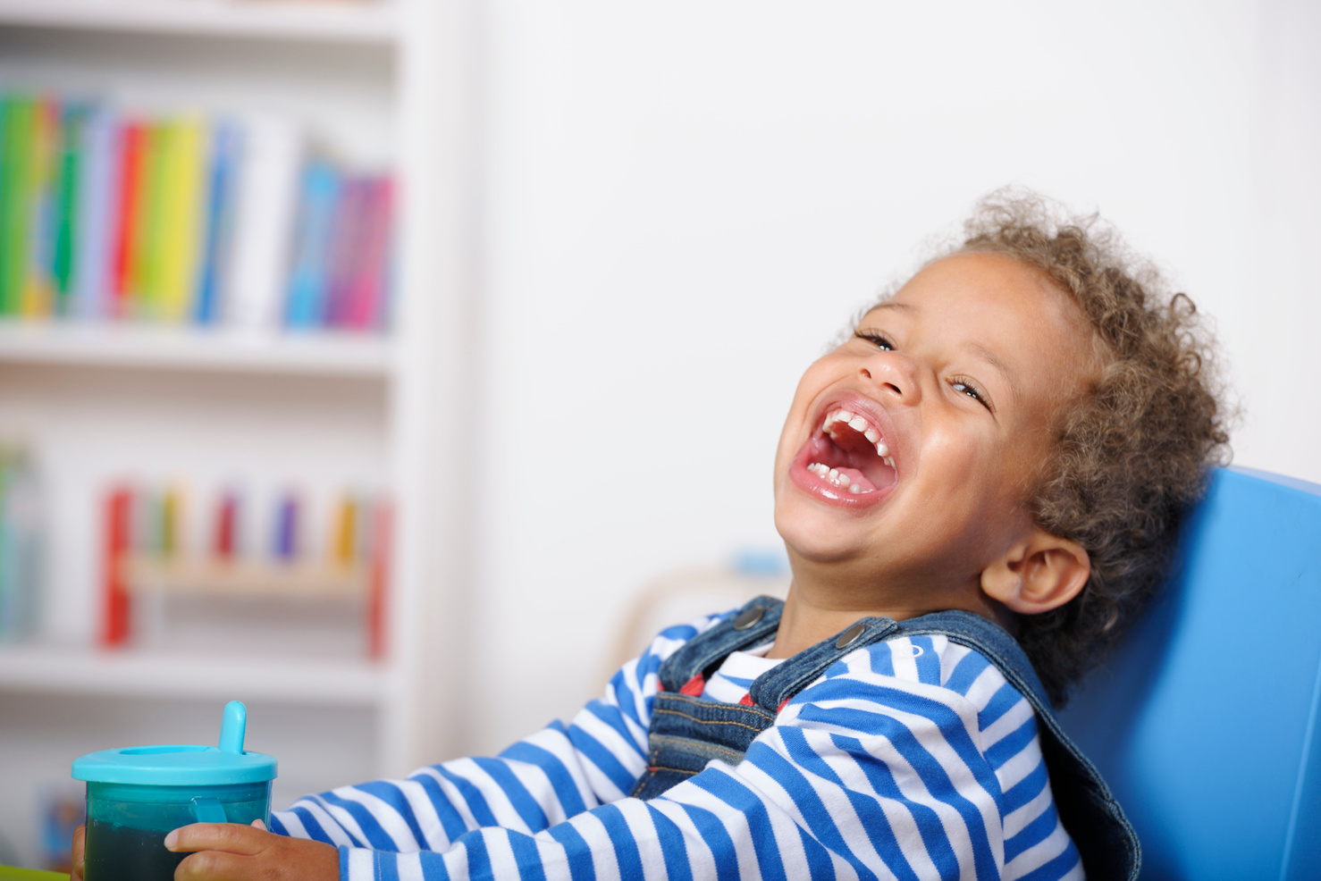 Happy Toddler Laughing While Holding A Cup